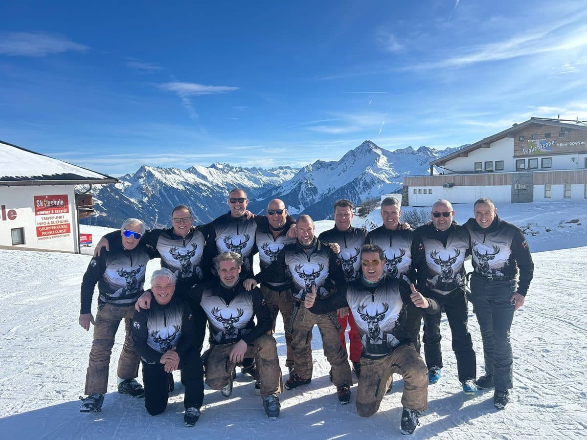 Skiclub in bijpassende GUTSKI skipullies op de piste in de Alpen